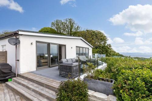 a small white house with a wooden deck at Cove Lodge in Portland