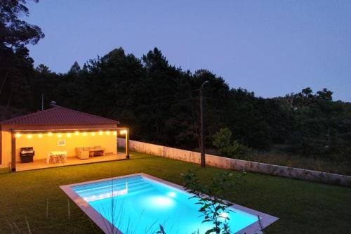 a backyard with a swimming pool and a house at Casa do Bosque in Vila Nova de Cerveira