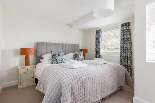 a white bedroom with a large bed and a window at Cove Lodge in Portland