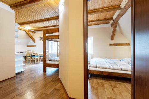 1 dormitorio con 1 cama y comedor en Apartmány Klínovec - Penzion Jonas, en Loucná pod Klínovcem