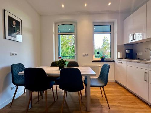 Una cocina y un comedor con mesa y sillas. en Apartment in Bad Wilhelmshöhe mit großem Balkon im Grünen und kostenfreien Parkplätzen, en Kassel