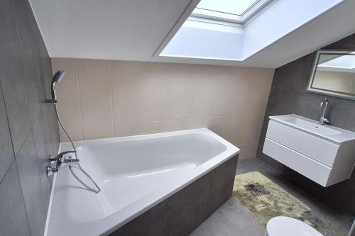 uma casa de banho com uma banheira e uma clarabóia em Gemütliche Wohnung in Bissingen em Bietigheim-Bissingen