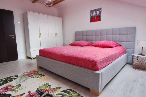 um quarto com uma cama com lençóis cor-de-rosa e almofadas cor-de-rosa em Gemütliche Wohnung in Bissingen em Bietigheim-Bissingen