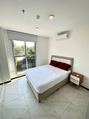 a bedroom with a bed and a large window at Hermoso apartamento en Asuncion in Asunción