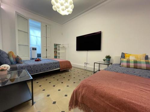 1 dormitorio con 2 camas y TV de pantalla plana en Bcn Centric Rooms en Barcelona