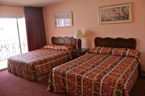 um quarto de hotel com duas camas e uma janela em Royal Century Hotel at LAX em Inglewood