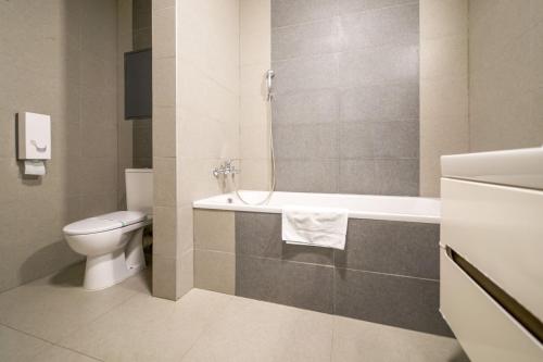 a bathroom with a toilet and a bath tub at Vesna Convenient Apartment in Bratislava