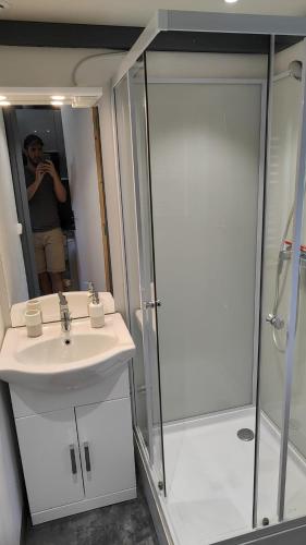 une personne prenant une photo d'une salle de bains avec lavabo et douche dans l'établissement Bungalow/chalet (HLL) à Serre Ponçon, proche stations de ski, à Pontis