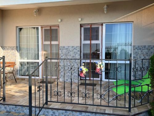 a balcony with a fence and a table and chairs at Flower Breeze in Chebanka