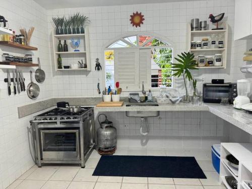 a kitchen with a stove and a sink at Casa Amarela, para veraneio em Areia Dourada in Cabedelo