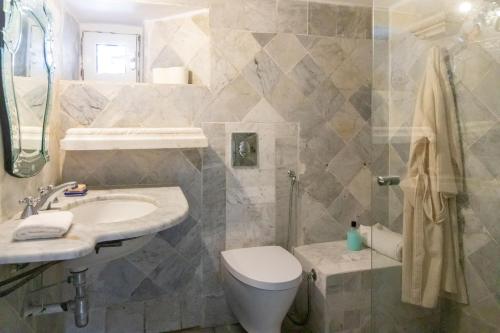 een badkamer met een toilet, een wastafel en een douche bij Dar Jamila La Dolce Vita au coeur de la Medina in Hammamet