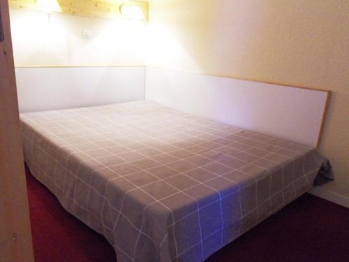 un petit lit dans une petite pièce avec un bleu dans l'établissement Appartement 5 pers, accès pistes, animaux admis - FR-1-181-2153, à La Plagne Tarentaise