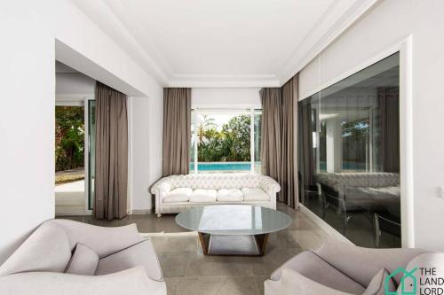 sala de estar con sofá y mesa en Villa Cassel: Villa avec piscine et vue sur le lac, en Túnez