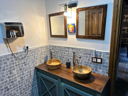 a bathroom with two sinks on a wooden counter at Karga Butik Otel in Diyarbakır