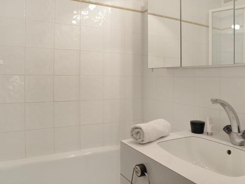une salle de bain blanche avec une baignoire et un lavabo dans l'établissement Studio lumineux au pied des pistes avec balcon, parking et animaux admis - FR-1-181-2224, à La Plagne Tarentaise