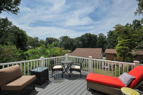 a deck with chairs and a table on a balcony at House Near Bju, Furman, & Town in Greenville