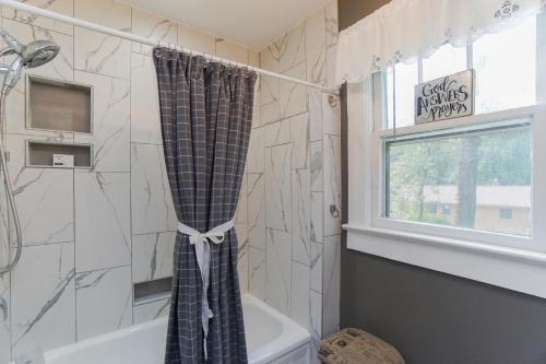 een badkamer met een douchegordijn en een bad bij House Near Bju, Furman, & Town in Greenville