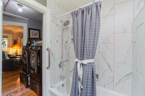 a bathroom with a shower with a shower curtain at House Near Bju, Furman, & Town in Greenville
