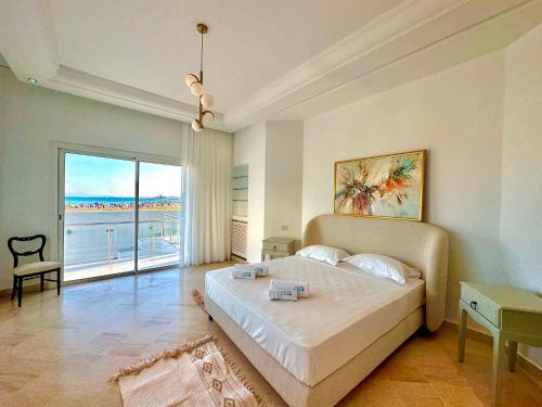 1 dormitorio con cama y vistas al océano en Omnya Carthage Beachfront Luxury Villa, en Cartago