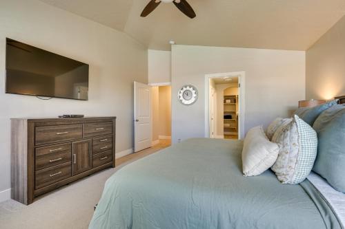a bedroom with a bed and a dresser with a flat screen tv at Hurricane Getaway with Private Pool, Mtn Views! in Hurricane