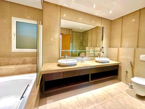 y baño con 2 lavabos, bañera y aseo. en Omnya Carthage Beachfront Luxury Villa, en Cartago
