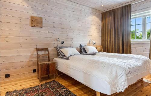 1 dormitorio con 1 cama y pared de madera en Lovely Home In Dovre With Kitchen, en Dovre