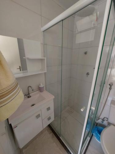 a bathroom with a glass shower and a sink at A Casa Morro do Moreno in Vila Velha