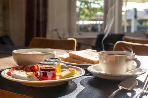 - une table avec deux assiettes de nourriture et une tasse de café dans l'établissement Cawdor House B&B, à Nairn