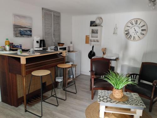 uma sala de estar com uma secretária, cadeiras e um relógio em Launay em Chènehutte-les-Tuffeaux