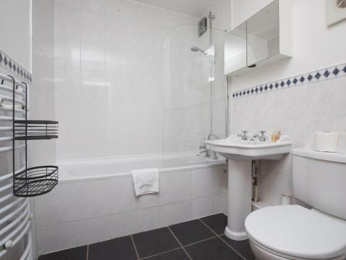 a white bathroom with a toilet and a sink at Cosy 2 Bedroom Flat with Parking and 20mins Train to London in Maidenhead