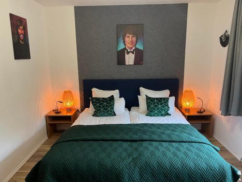 - une chambre avec un lit avec une couverture verte et 2 lampes dans l'établissement Am Obersee Hotel, à Simmerath