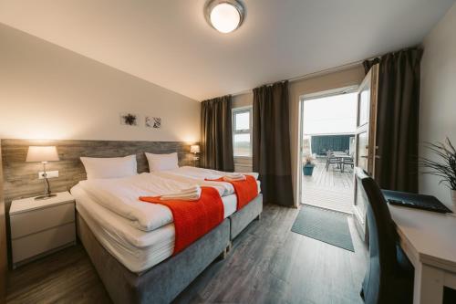 um quarto de hotel com uma cama e uma grande janela em Hotel Vos em Hella