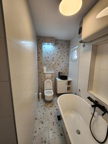 a bathroom with a tub and a toilet and a sink at Modern Cozy Suite - Vracar in Vračar (historical)