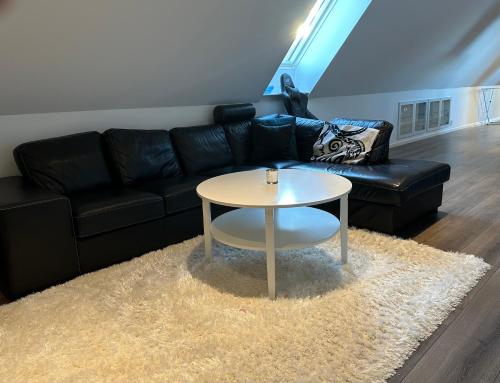 a living room with a black couch and a table at Yngsjövång in Yngsjö