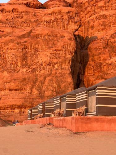 a building in the desert next to a mountain at Wadi Rum Mars Camp in Wadi Rum