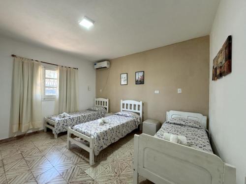 1 dormitorio con 3 camas y ventana en La Pilar en Formosa