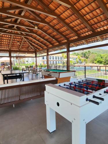 a patio with two ping pong tables and pool tables at Flat da Mata - Resort Quinta Santa Bárbara in Pirenópolis