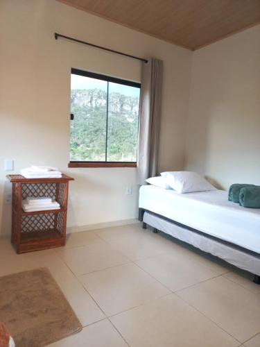 1 dormitorio con cama y ventana en Recanto Cachoeiras de Ibicoara en Ibicoara
