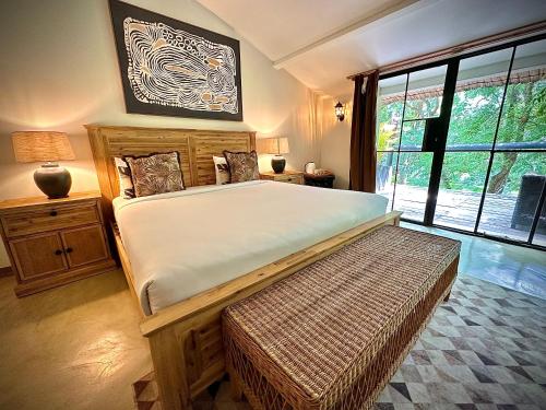 um quarto com uma cama grande e uma janela grande em Sakae Paradise Resort em Lusaka