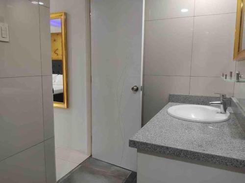 a white bathroom with a sink and a mirror at KANDI Palace, 2-Bedroom serviced Apartment in Angeles