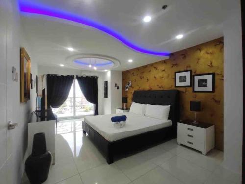 a bedroom with a large bed with a blue light on the ceiling at KANDI Palace, 2-Bedroom serviced Apartment in Angeles