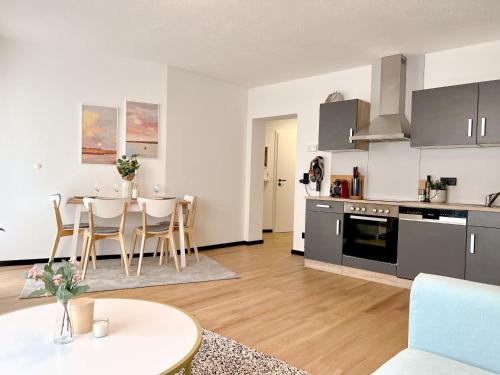 een keuken en een woonkamer met een tafel en stoelen bij Boho Home - mit Balkon, Parkplatz und Netflix in Trier