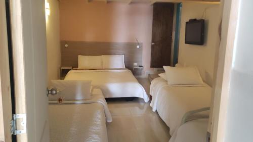 a hotel room with two beds and a tv at Mirador San Jose in Santa Rosa de Cabal