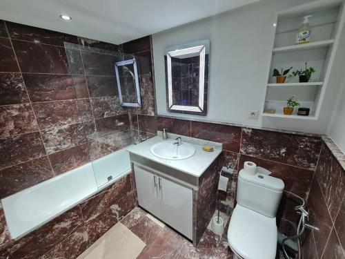 a bathroom with a sink and a tub and a toilet at Superbe appartement lumineux in Marrakesh