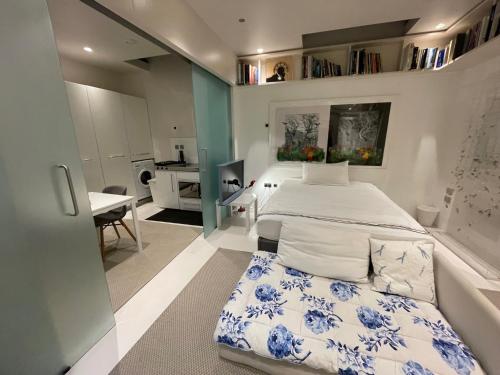 a bedroom with a bed and a table in a room at Modern self-contained Ground and Basement studios in London