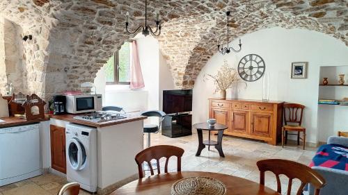 薩拉瓦的住宿－Gîtes de la place du château，厨房以及带桌子和微波炉的客厅。