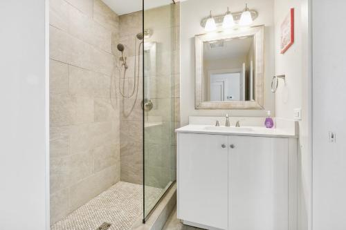 a bathroom with a shower and a sink and a mirror at Modern Condo Walking Distance to Must-See Attractions of NOLA in New Orleans