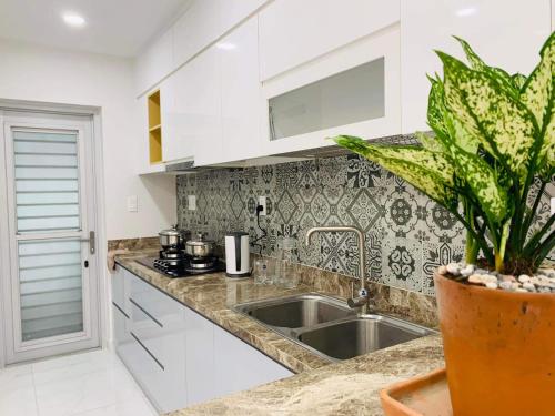 a kitchen with white cabinets and a sink at SECC Scenic Valley Apartment in Ho Chi Minh City