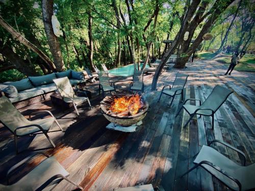 a fire pit sitting on a wooden deck with chairs at Sakae Paradise Resort in Lusaka