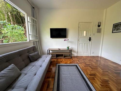 a living room with a couch and a television at Casa Palácio de Cristal no centro Histórico de Petrópolis in Petrópolis